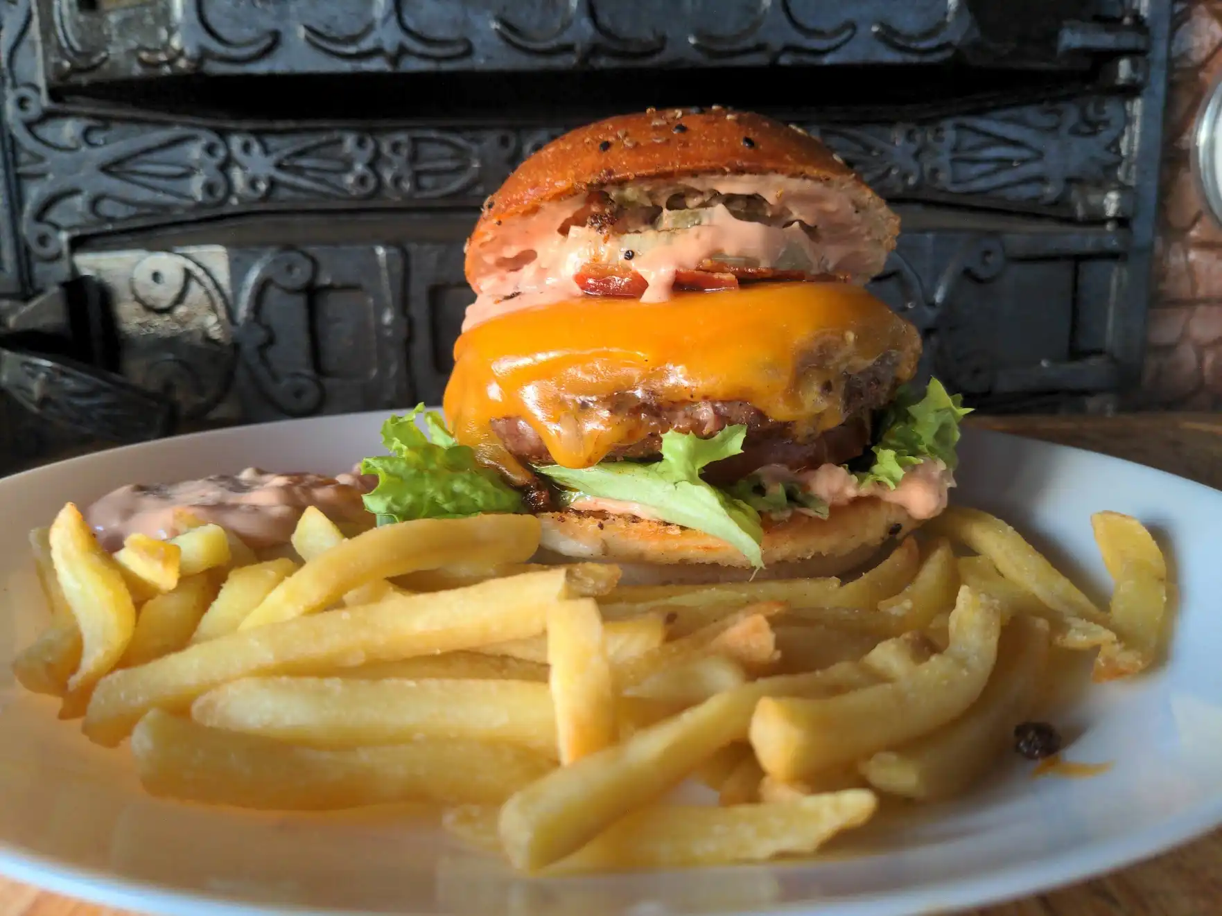 Adding the onion and top bun, completing the burger assembly.